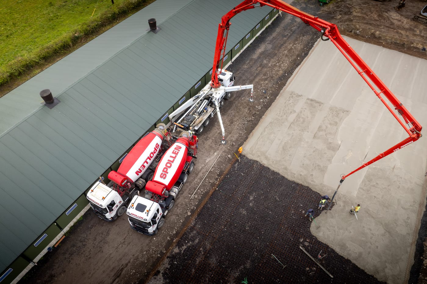 Spollen Concrete mixer truck and concrete pump delivering a pour, aerial top-down view at the Glasson plant