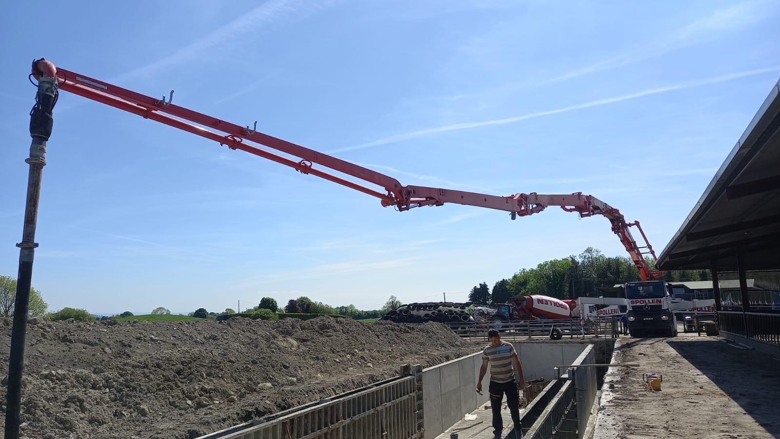 The boom pump reaching the full length of a slatted tank channel