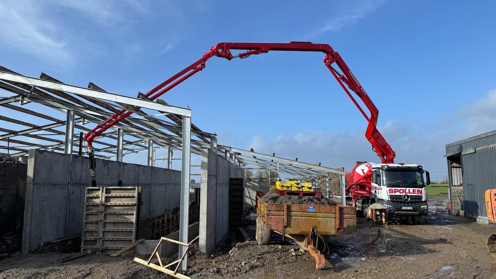 The boom arcing over the steel frame of a new agricultural shed
