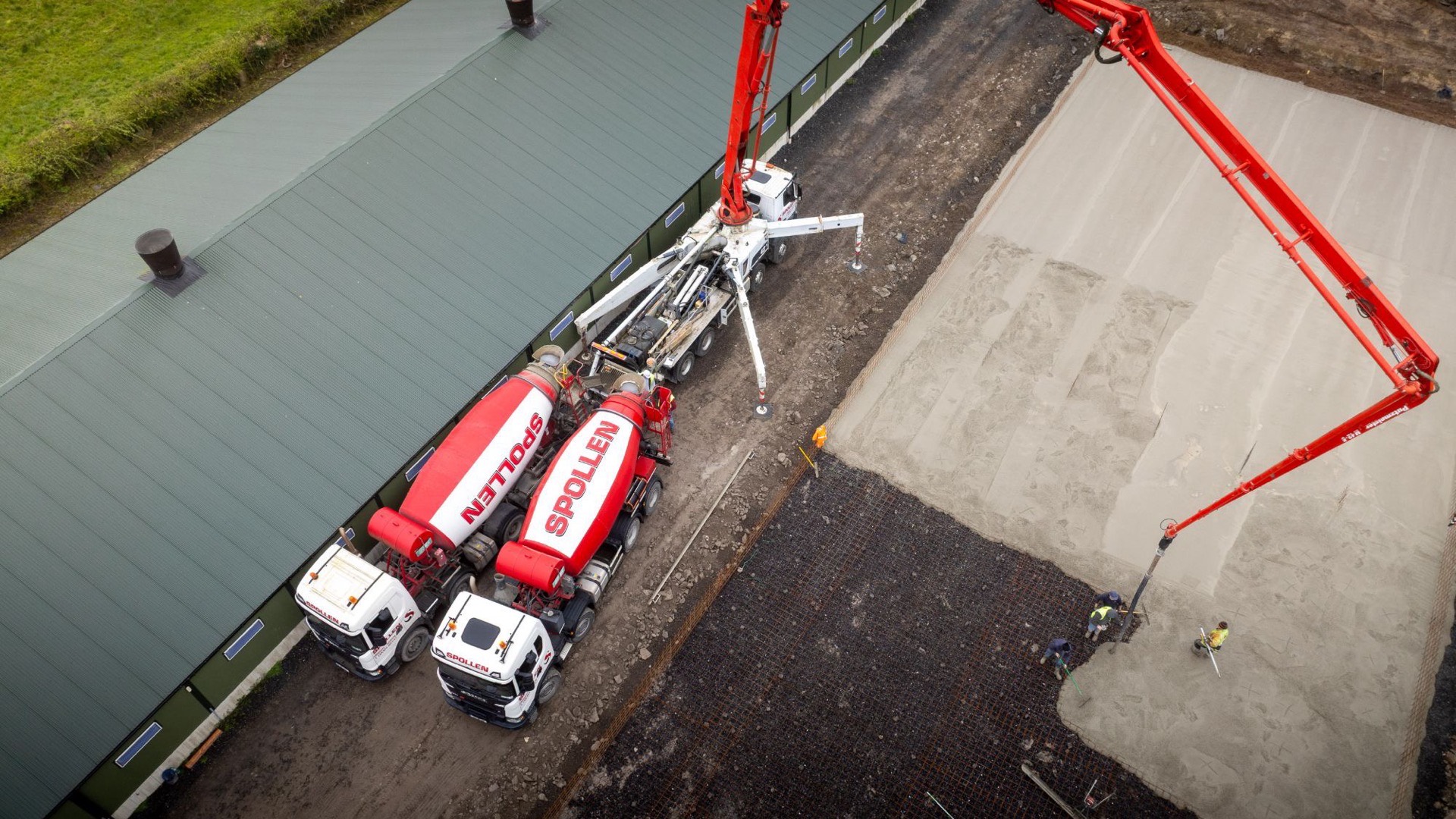Overhead view of the boom reaching out across the slab with two mixers feeding the pump