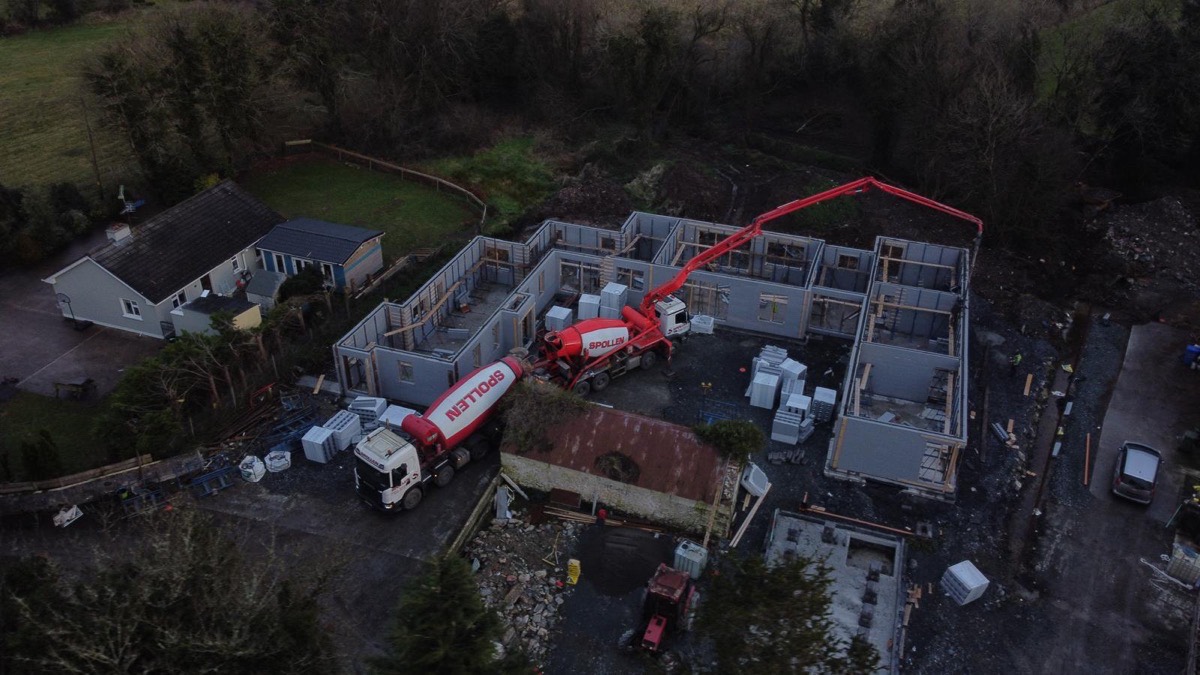 The Spollen 24m PUMI pump-mixer placing concrete on a multi-unit build at dusk